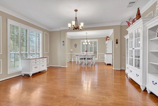 unfurnished dining area featuring ornamental molding, light hardwood / wood-style flooring, and a chandelier