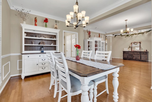 dining area with a chandelier, light hardwood / wood-style floors, and crown molding