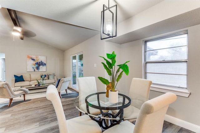 dining space with ceiling fan, wood-type flooring, and vaulted ceiling