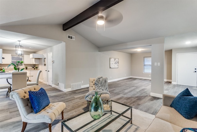 living room with lofted ceiling with beams, light hardwood / wood-style flooring, and ceiling fan