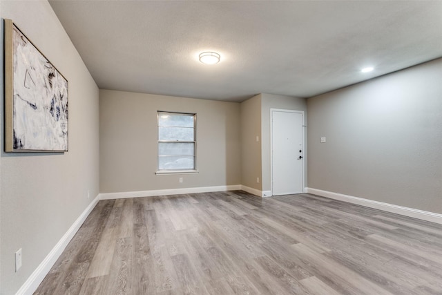 empty room featuring a textured ceiling and light hardwood / wood-style floors