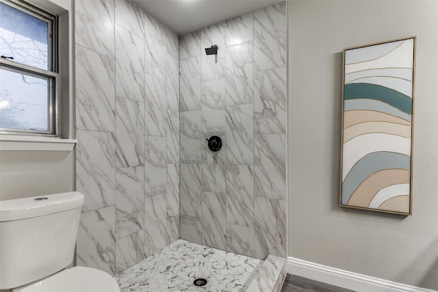 bathroom featuring toilet and tiled shower