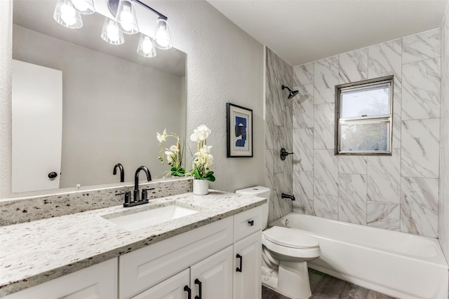 full bathroom featuring vanity, toilet, wood-type flooring, and tiled shower / bath