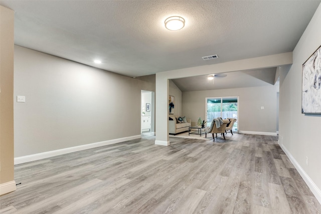 living room featuring light hardwood / wood-style floors and a textured ceiling