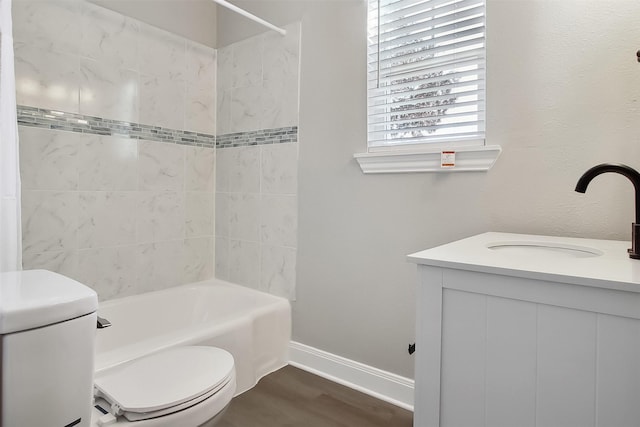 full bathroom with tiled shower / bath, vanity, toilet, and hardwood / wood-style floors