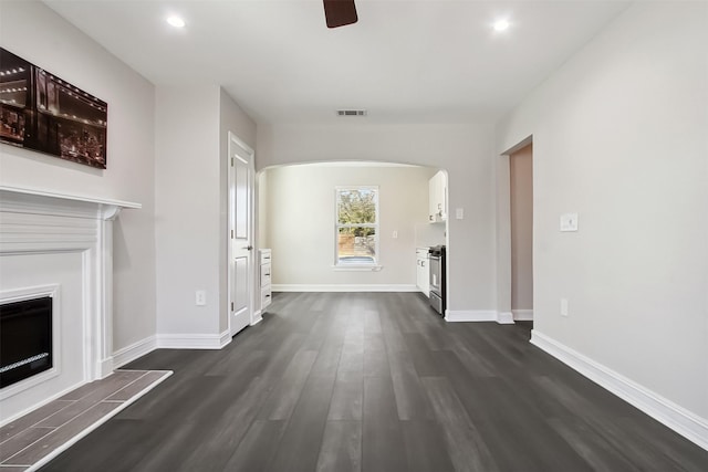 unfurnished living room featuring dark hardwood / wood-style flooring and ceiling fan