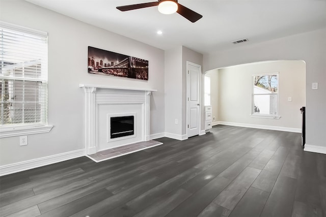 unfurnished living room with dark wood-type flooring and ceiling fan