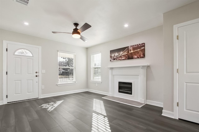 unfurnished living room with dark wood-type flooring and ceiling fan