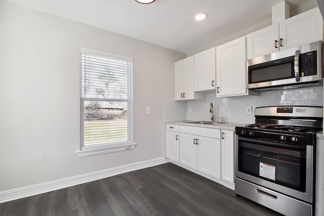 kitchen featuring stainless steel appliances, white cabinetry, a wealth of natural light, and dark hardwood / wood-style flooring