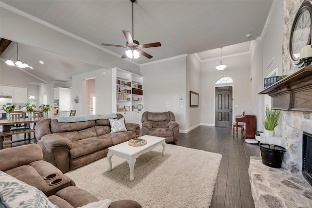 living room with dark wood-type flooring, high vaulted ceiling, crown molding, a fireplace, and ceiling fan with notable chandelier