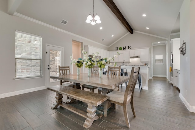 dining room featuring lofted ceiling with beams, ornamental molding, and a chandelier