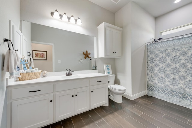 bathroom featuring walk in shower, vanity, and toilet