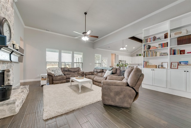 living room featuring vaulted ceiling with beams, crown molding, a fireplace, and ceiling fan with notable chandelier