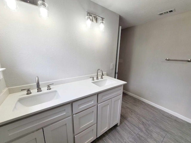 bathroom featuring a textured ceiling and vanity