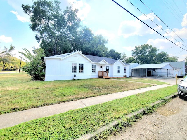 view of front of home with a front yard and a carport