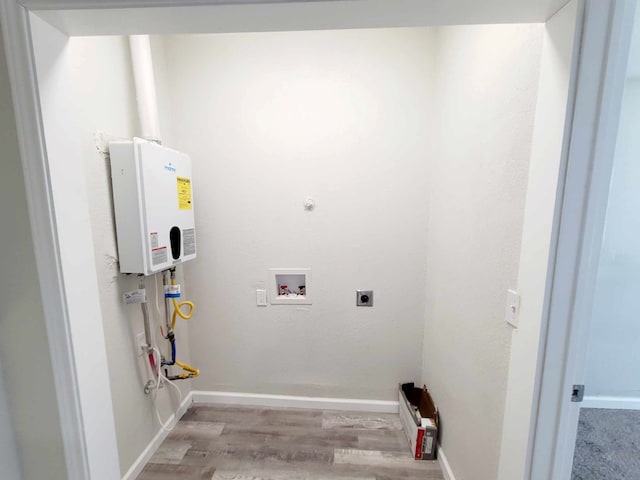 laundry room featuring hookup for an electric dryer, washer hookup, light hardwood / wood-style flooring, and water heater