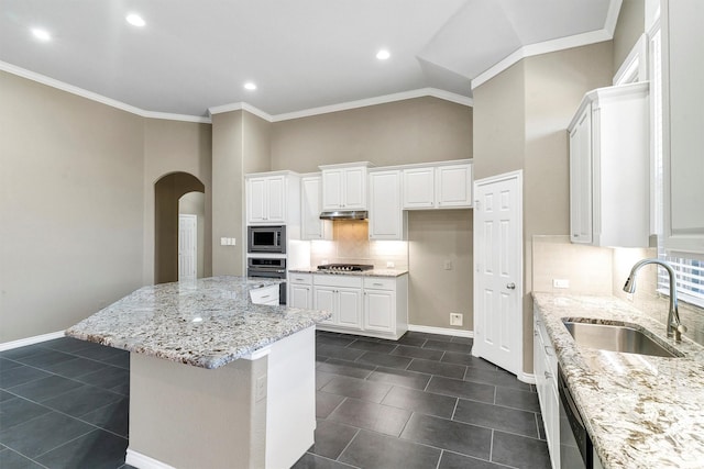 kitchen with light stone countertops, appliances with stainless steel finishes, sink, and white cabinets