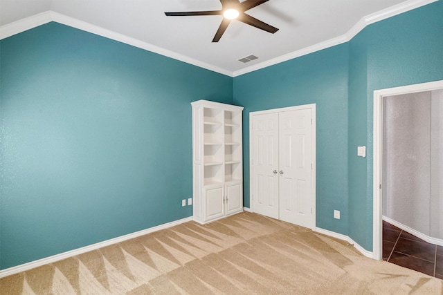 unfurnished bedroom featuring crown molding, carpet floors, and ceiling fan