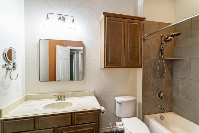 full bathroom featuring vanity, tiled shower / bath combo, and toilet