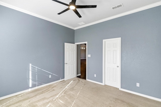 empty room with ceiling fan, ornamental molding, and carpet