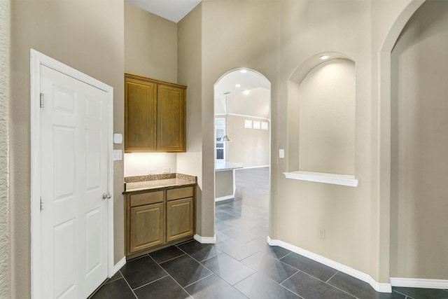 kitchen featuring a high ceiling and dark tile patterned flooring