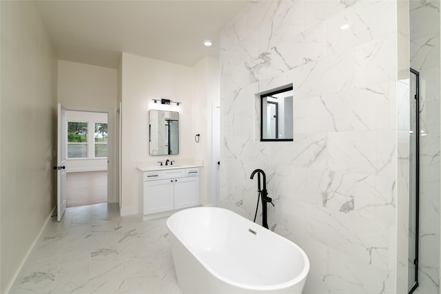 full bathroom with recessed lighting, marble finish floor, a freestanding bath, vanity, and baseboards