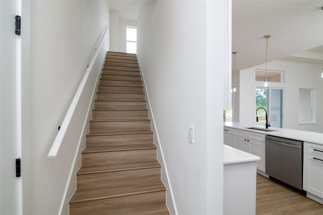 staircase with wood-type flooring and sink