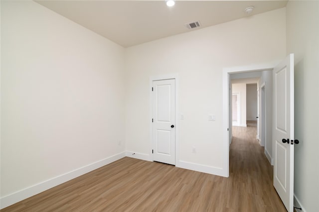 spare room featuring baseboards, visible vents, and light wood finished floors