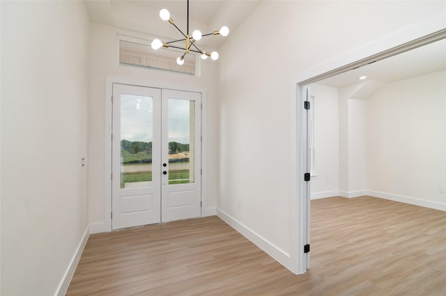 entryway with baseboards, an inviting chandelier, french doors, and light wood-type flooring