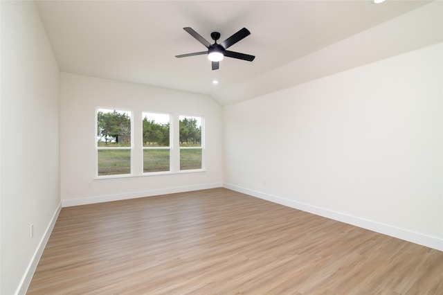 spare room with light wood finished floors, lofted ceiling, baseboards, and ceiling fan