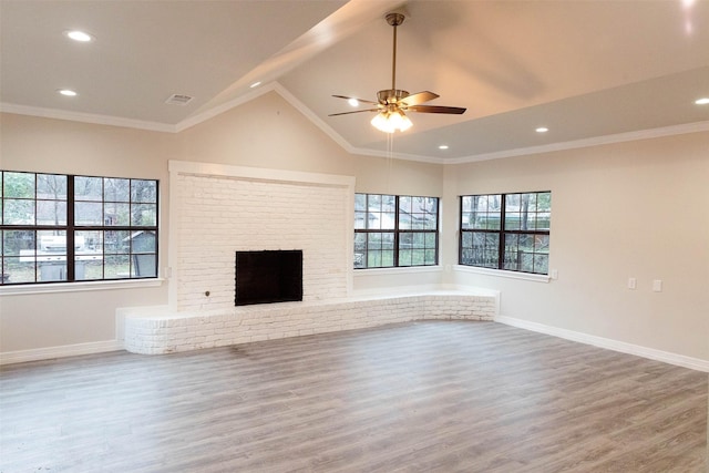 unfurnished living room with crown molding, a brick fireplace, hardwood / wood-style floors, and lofted ceiling