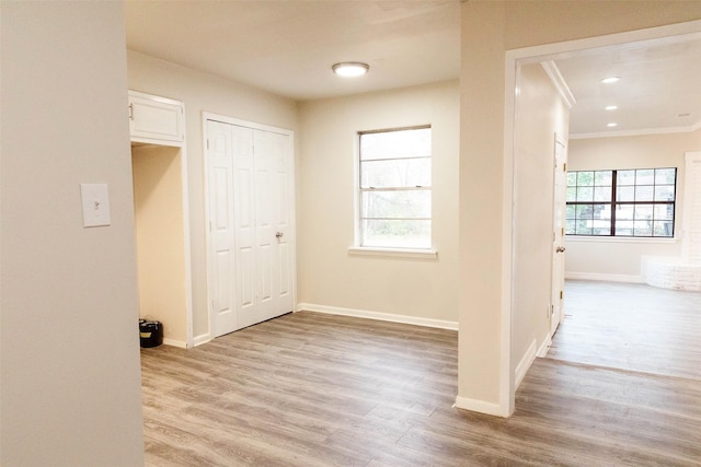 interior space featuring ornamental molding and light wood-type flooring