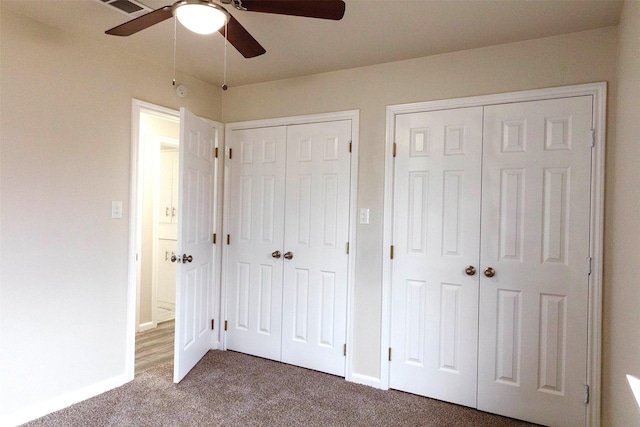 unfurnished bedroom with multiple closets, ceiling fan, and carpet floors