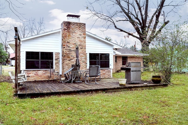 back of house featuring a lawn and a wooden deck