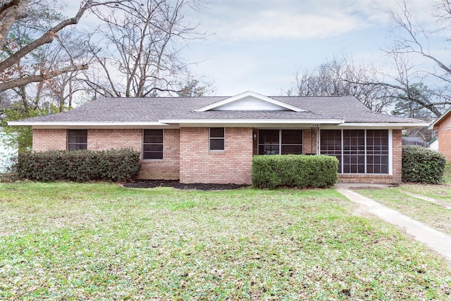 single story home featuring a sunroom and a front yard