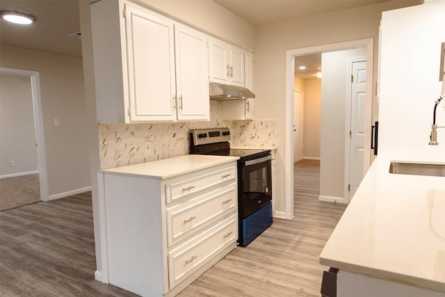 kitchen featuring backsplash, sink, electric range, light hardwood / wood-style flooring, and white cabinets