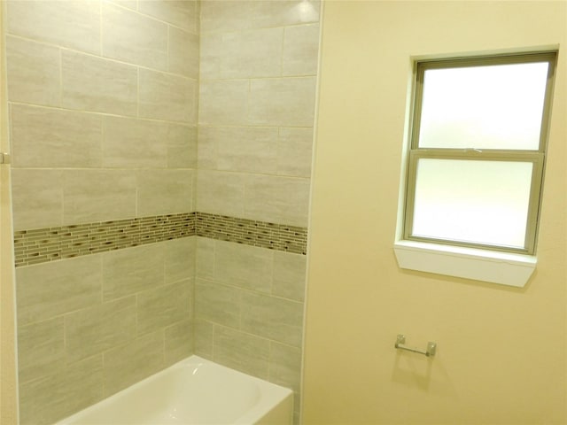 bathroom featuring tiled shower / bath