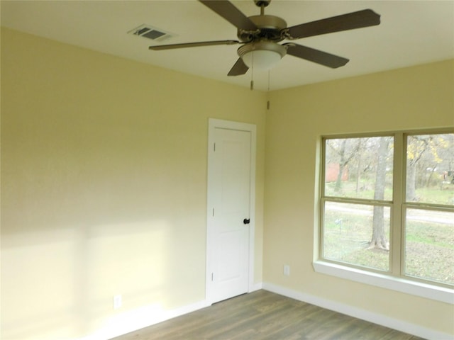 empty room with a wealth of natural light, ceiling fan, and hardwood / wood-style floors