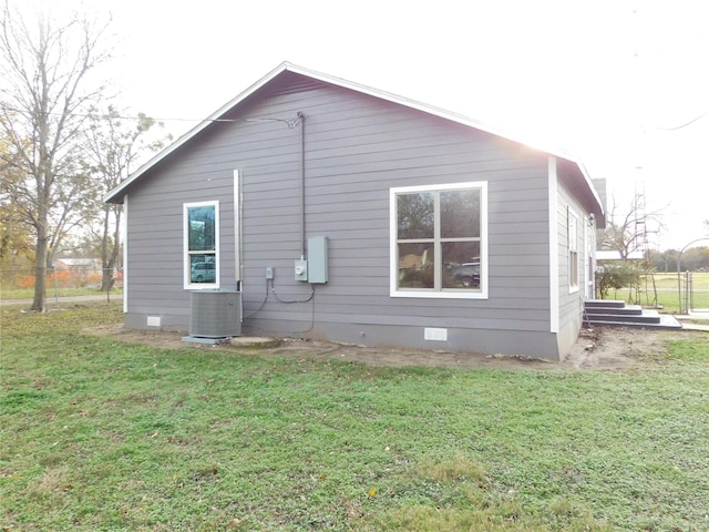 view of home's exterior with cooling unit and a lawn