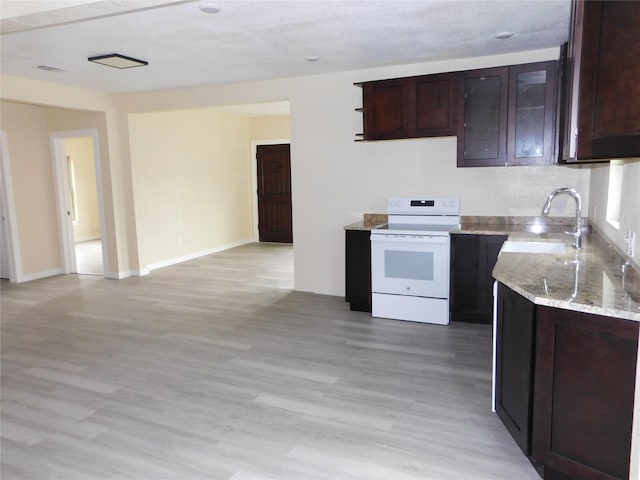 kitchen featuring light stone counters, light wood-type flooring, white electric range, and sink