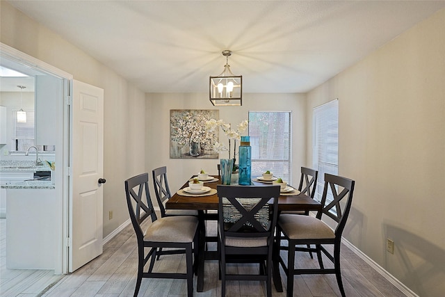 dining room featuring an inviting chandelier, sink, and wood-type flooring