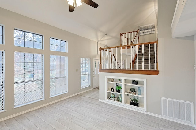 unfurnished living room featuring hardwood / wood-style flooring, vaulted ceiling, and ceiling fan