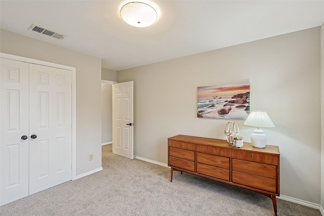 bedroom featuring light colored carpet and a closet