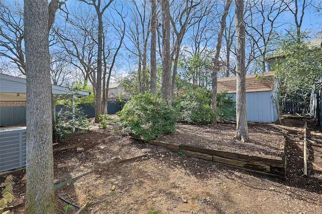 view of yard featuring central air condition unit and a storage unit