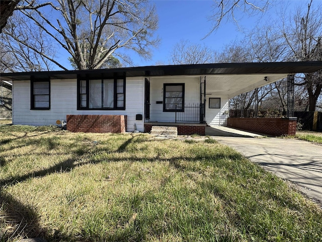 view of front of house with a front lawn, an attached carport, a porch, and driveway