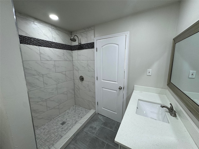 bathroom with vanity and tiled shower