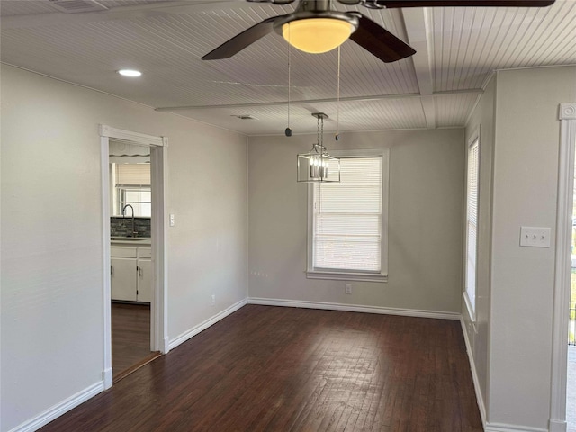 unfurnished dining area featuring plenty of natural light, wood finished floors, baseboards, and a sink