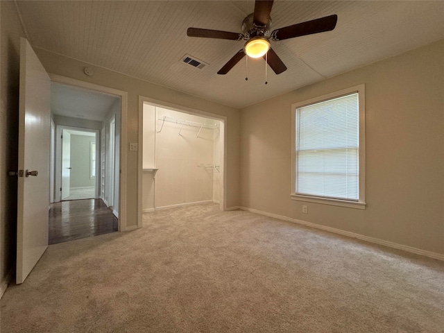 unfurnished bedroom featuring light colored carpet, ceiling fan, and a closet