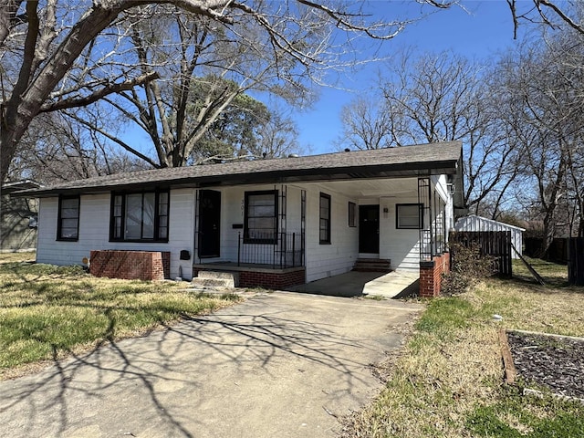 view of front of house featuring aphalt driveway, covered porch, and roof with shingles