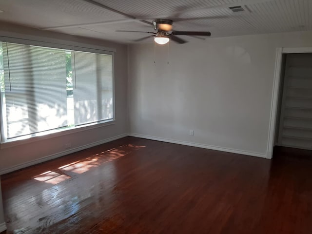 empty room with dark wood-type flooring and ceiling fan